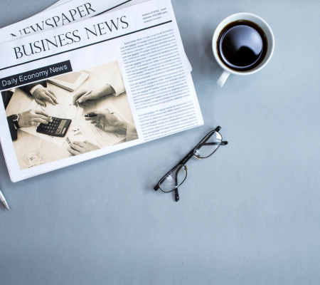 Business newspaper with coffee and reading glasses